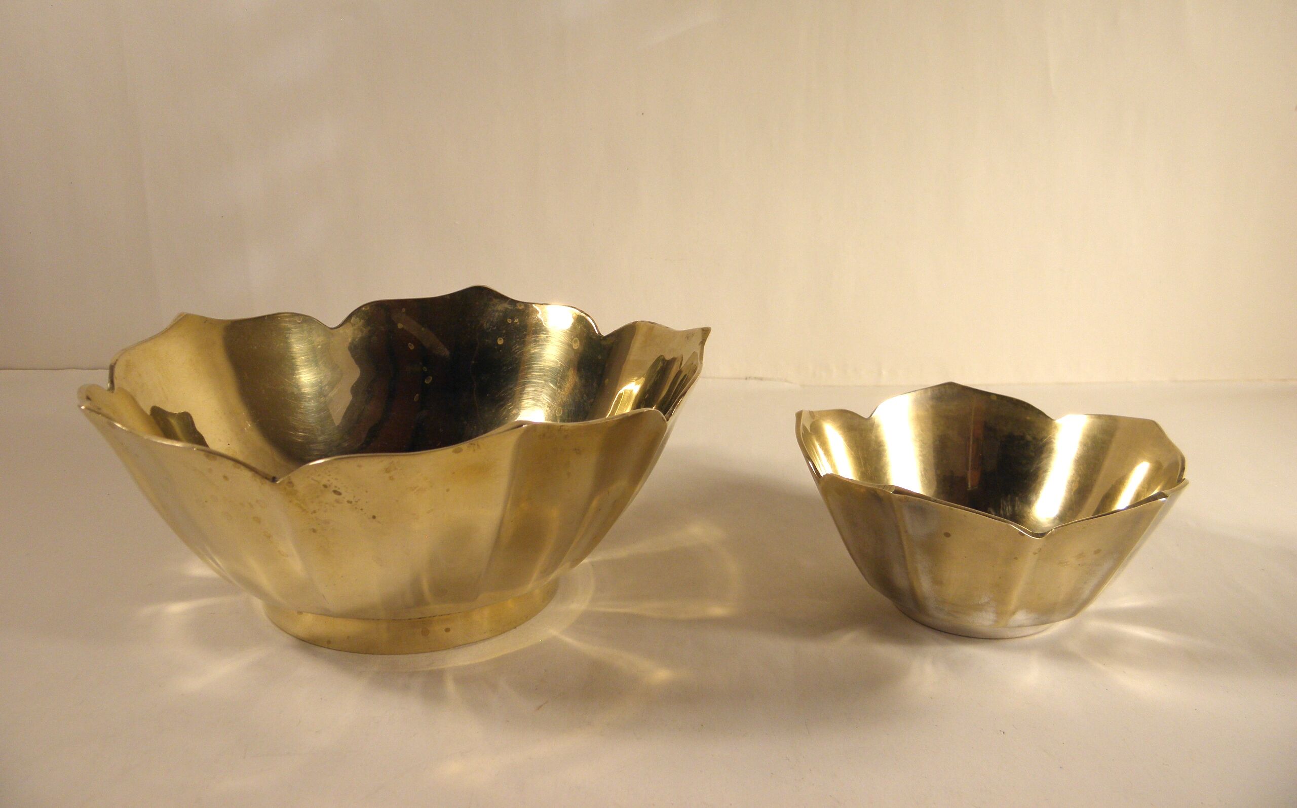 Two brass trundle cups