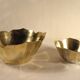 Two brass trundle cups