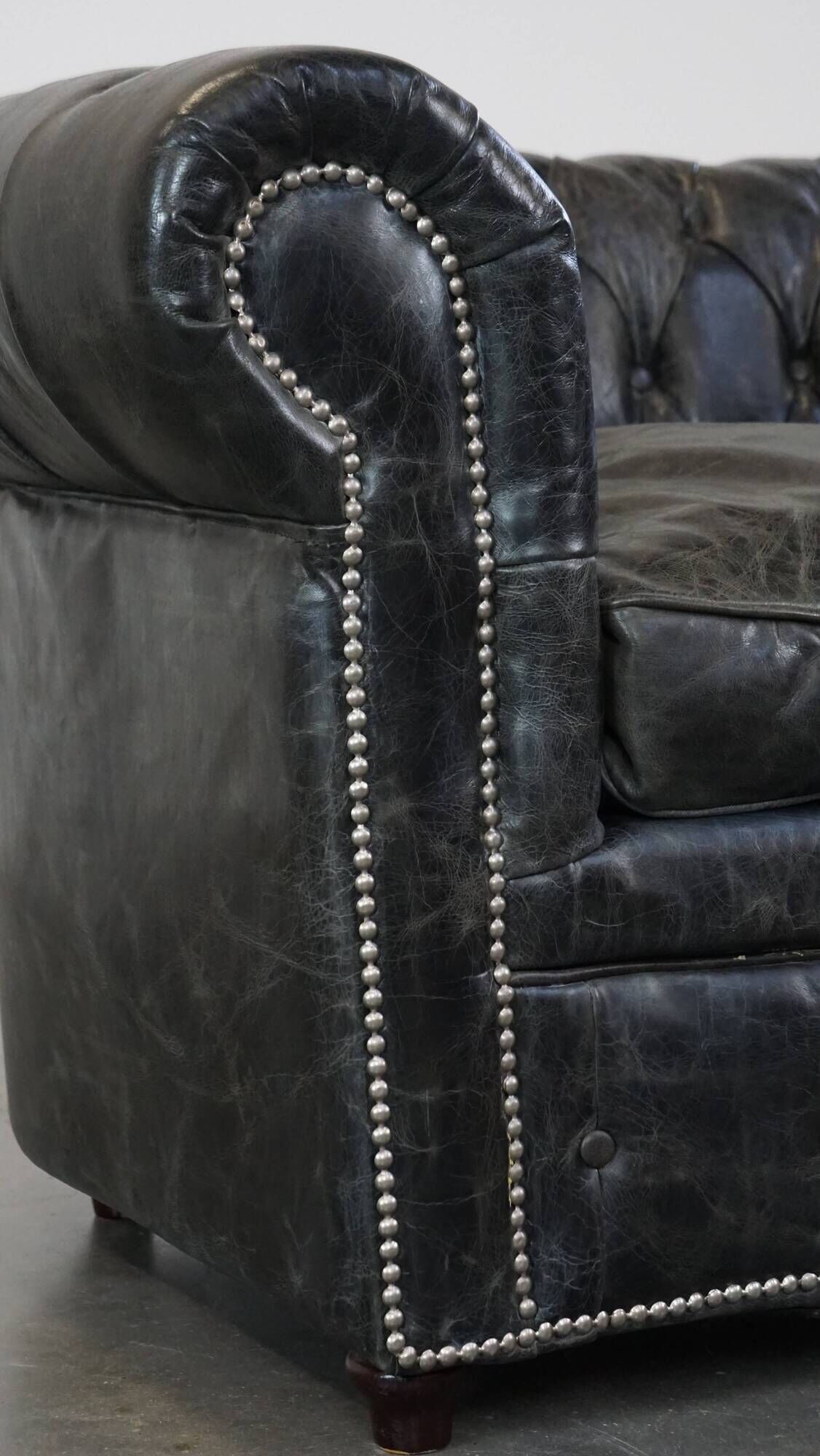 Spacious black cow leather chesterfield armchair with distinctive character