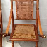 Pair of folding chairs in bamboo and caning, leather and brass