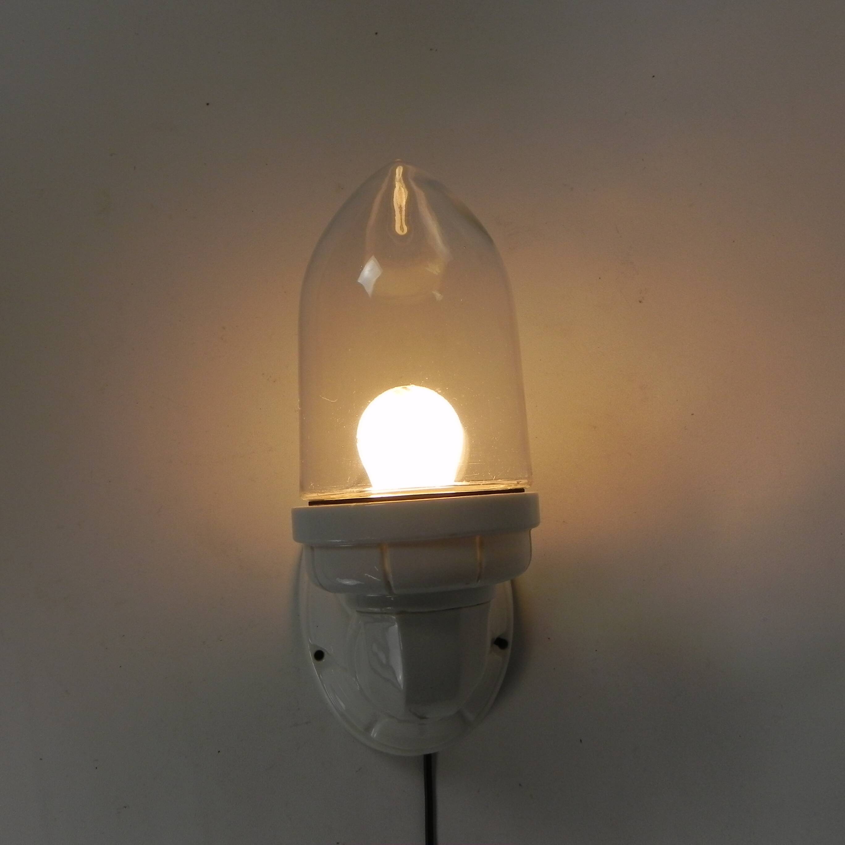 Wall lamp in porcelain with a transparent glass shade, 1930s.
