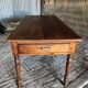 Antique Louis Philippe style farm table in solid cherry wood with turned base.