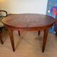 Oval extendable dining table in wood and walnut burl veneer.