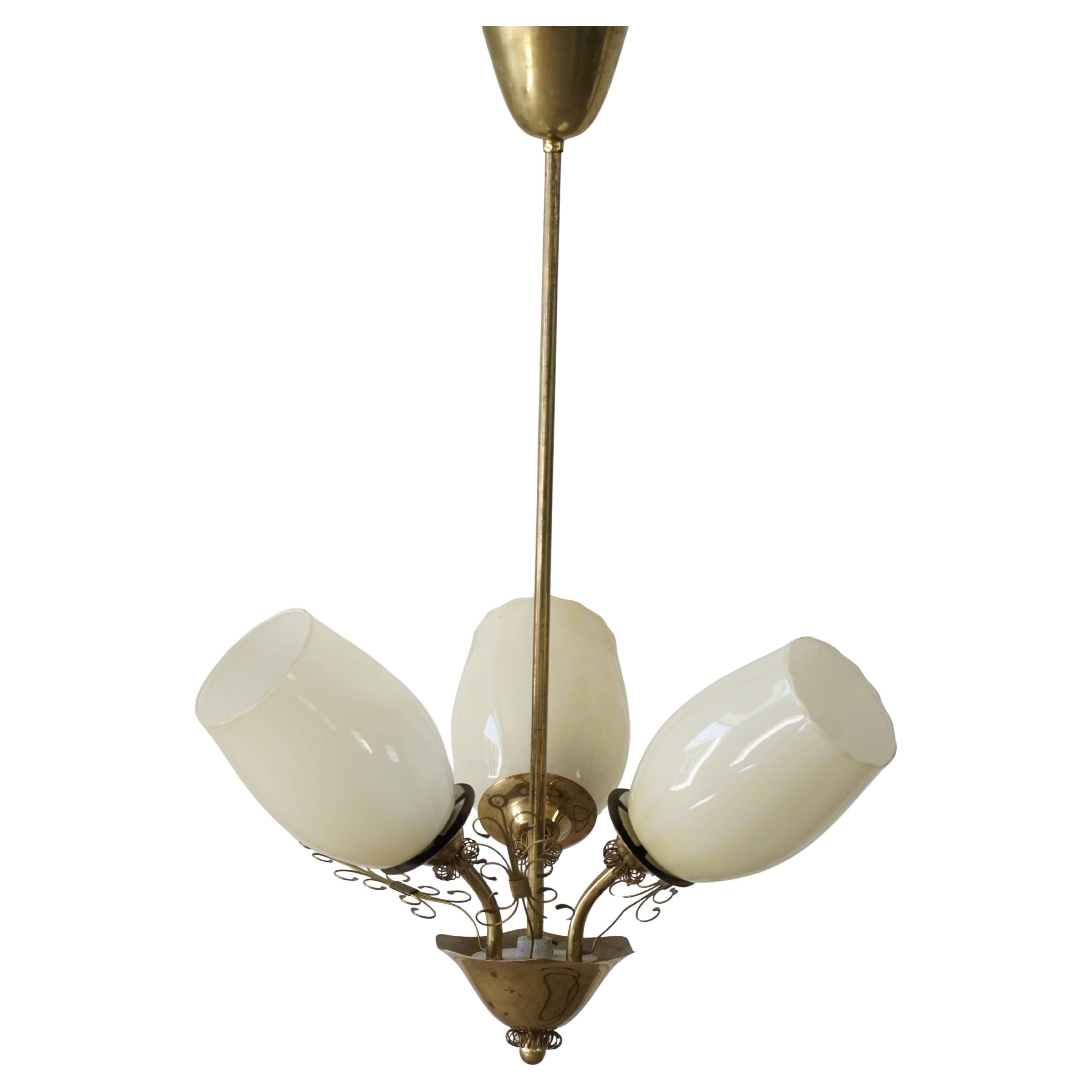Paavo Tynell for Idman Oy, three-branch chandelier in brass and glass, mid-century, 1940s.