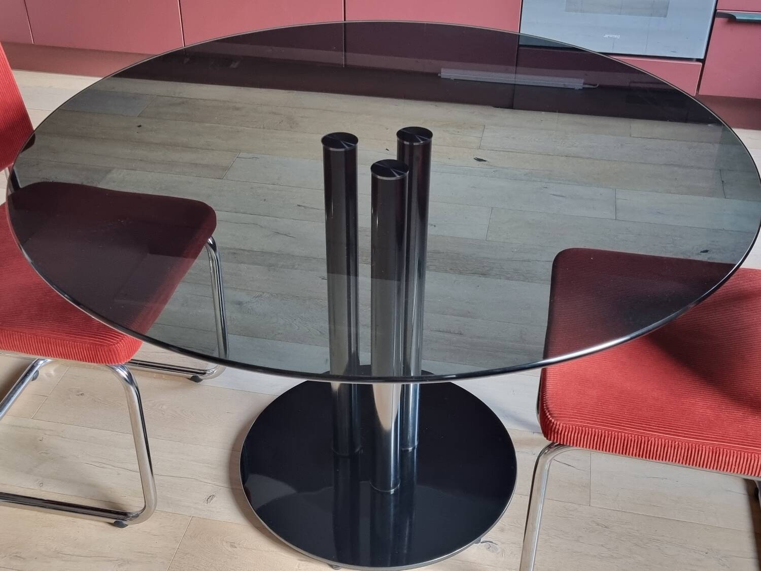 Round black smoked glass dining table + 2 terracotta chairs