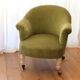 Toad in almond green velvet armchair on castors