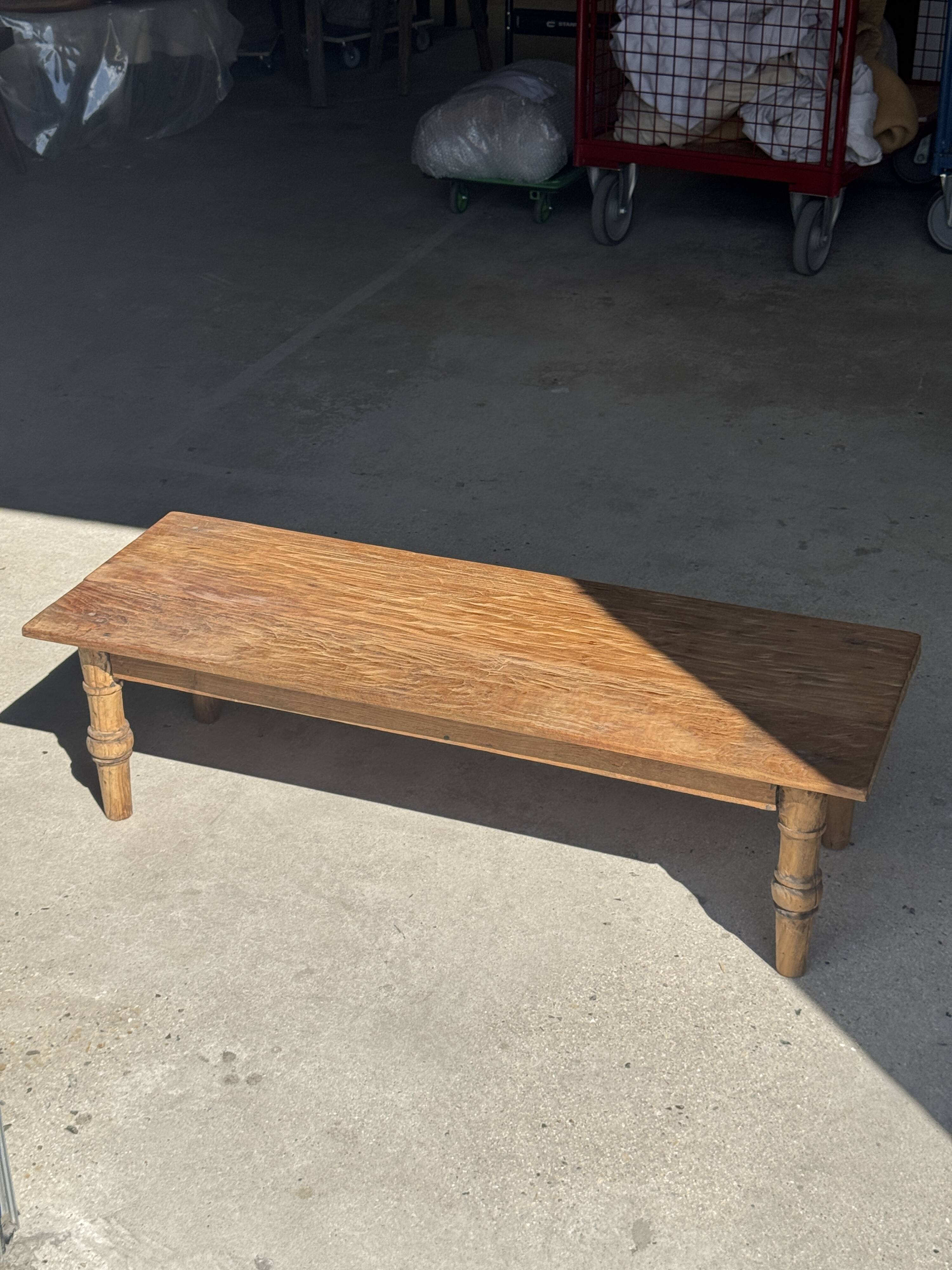 Brown Indonesian teak coffee table, with a border and cylindrical legs H40 L103.