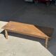 Brown Indonesian teak coffee table, with a border and cylindrical legs H40 L103.