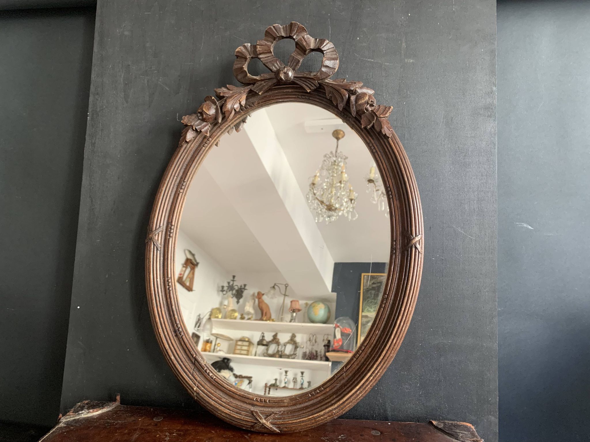 Antique oval mirror in carved wood and Louis XVI style knot
