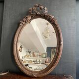 Antique oval mirror in carved wood and Louis XVI style knot