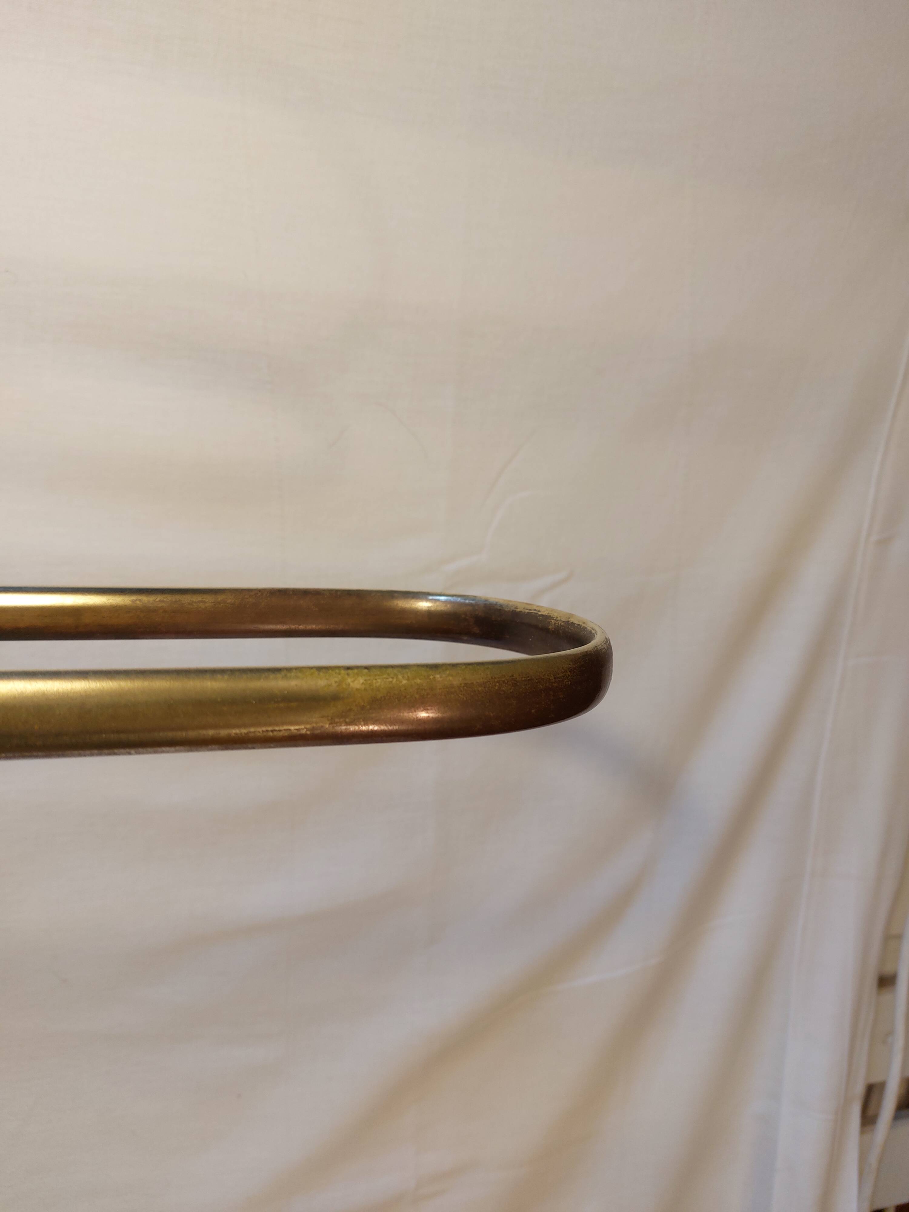 Old golden brass towel rack on baroque style foot
