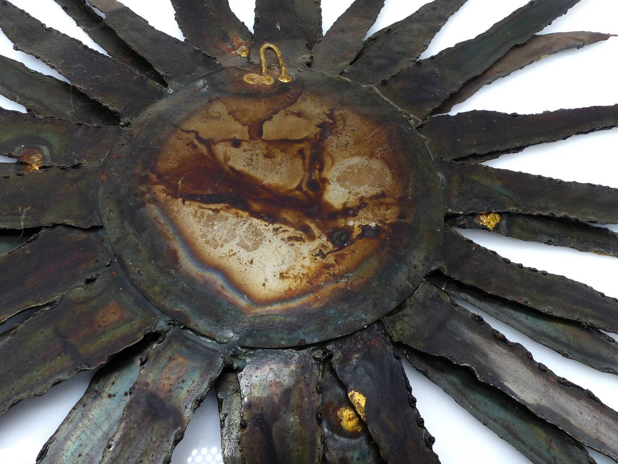 Large brutalist sun mirror in patinated metal with gold accents, 1970.
