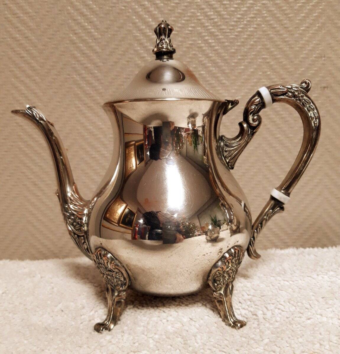 Silver-plated coffee and tea service including a coffee pot, a teapot, and a sugar bowl.