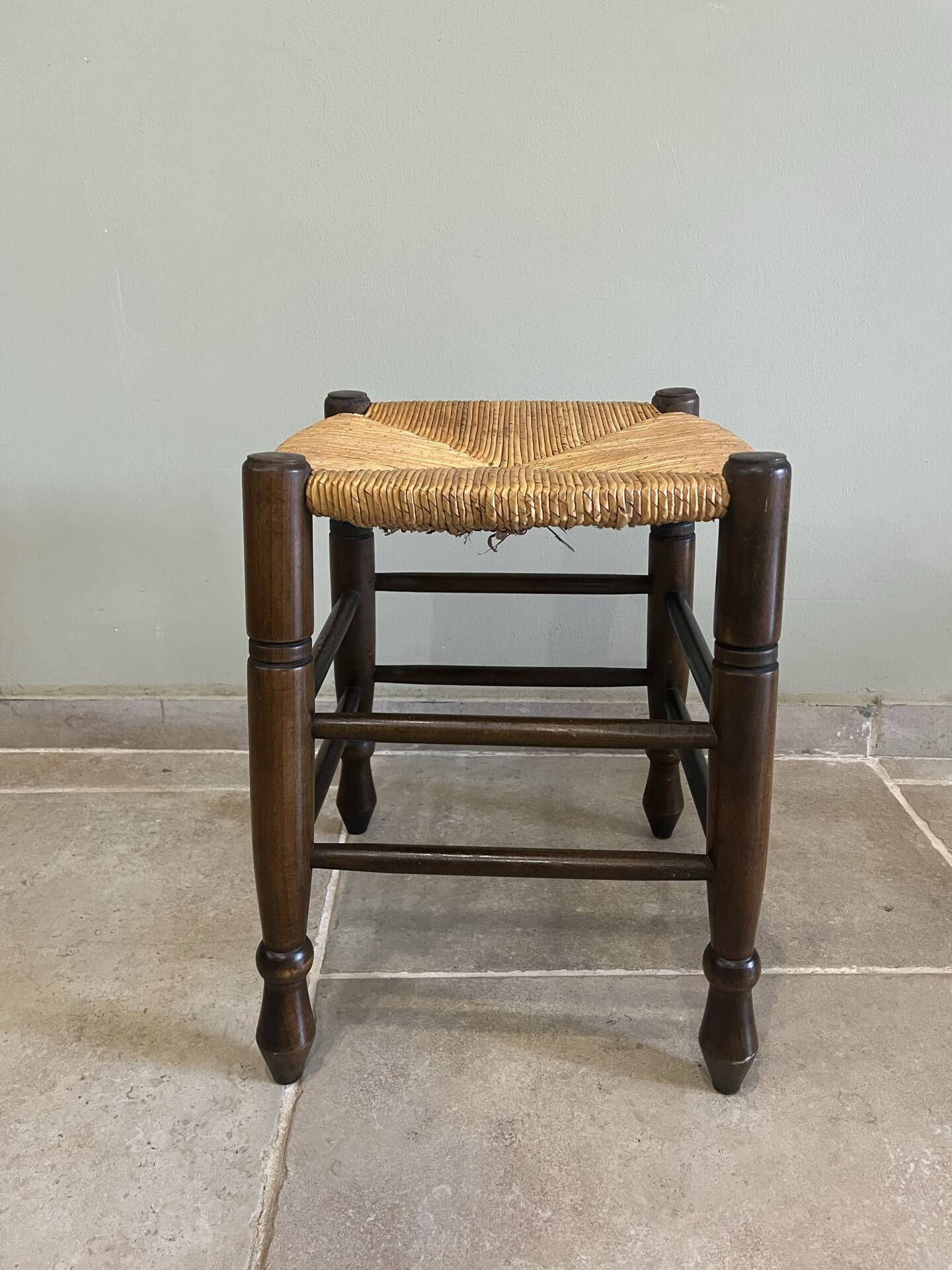 Wooden stool with a straw seat