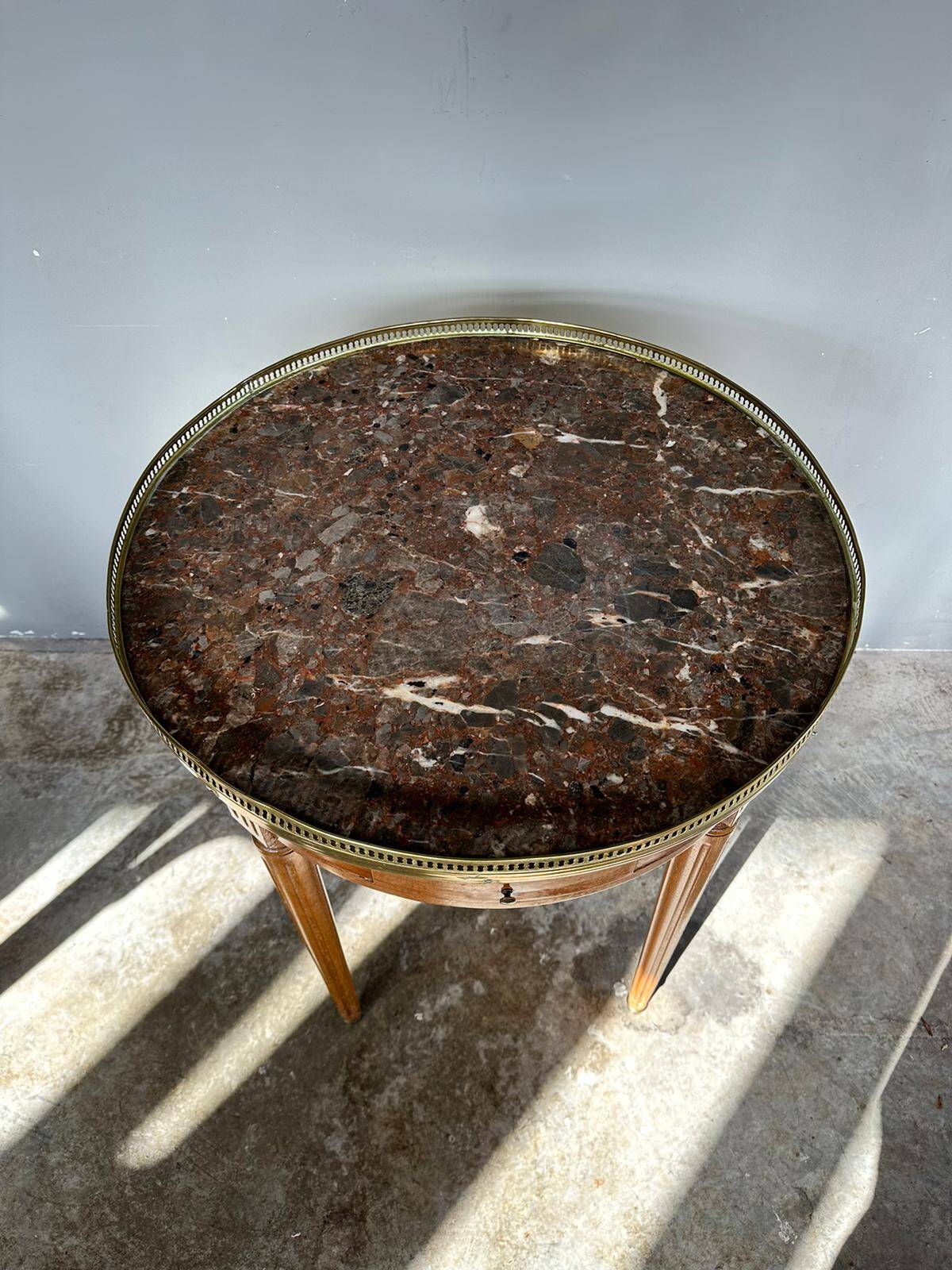 Hot water bottle table with a marble top and a brass gallery.