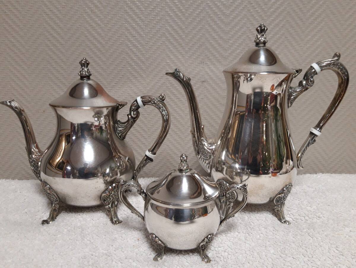 Silver-plated coffee and tea service including a coffee pot, a teapot, and a sugar bowl.