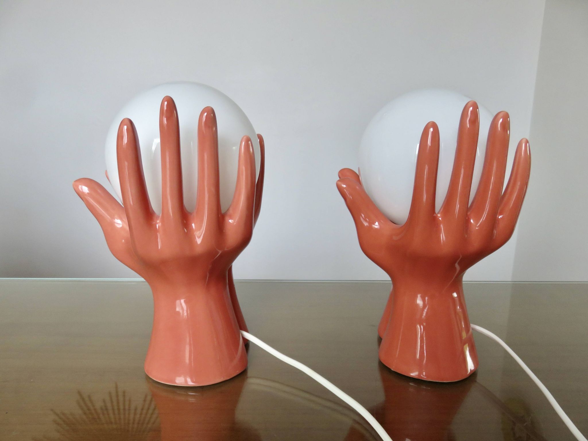 Pair of salmon-colored ceramic "hand" lamps with opaline globe, 80