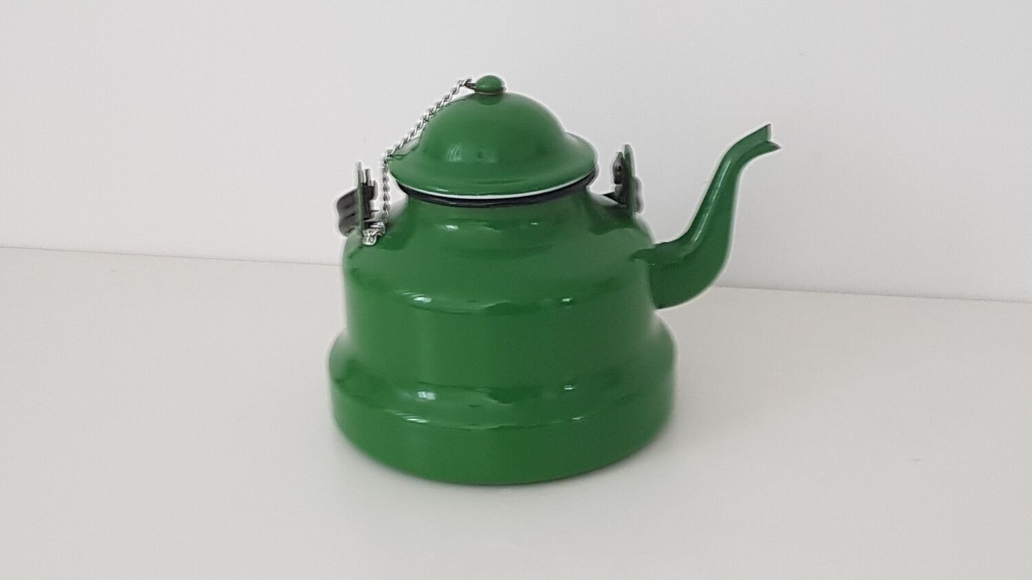 Old green kettle in enamelled metal