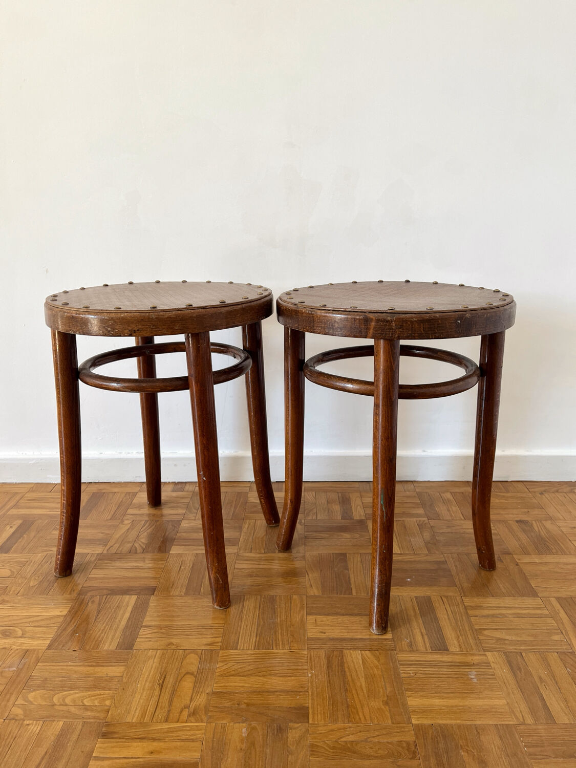 2 antique bistro stools with curved wood and caning effect.