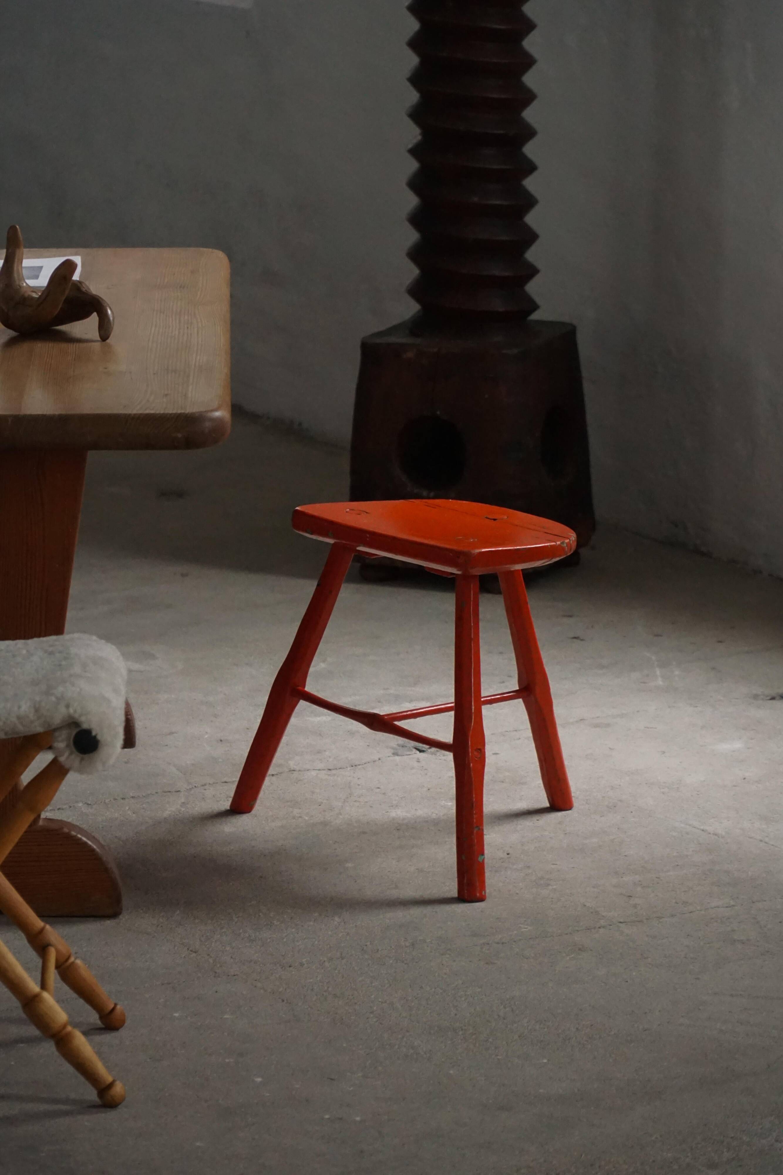 Pair of wooden stools painted in patinated red with flared legs, 1950s-1960s.
