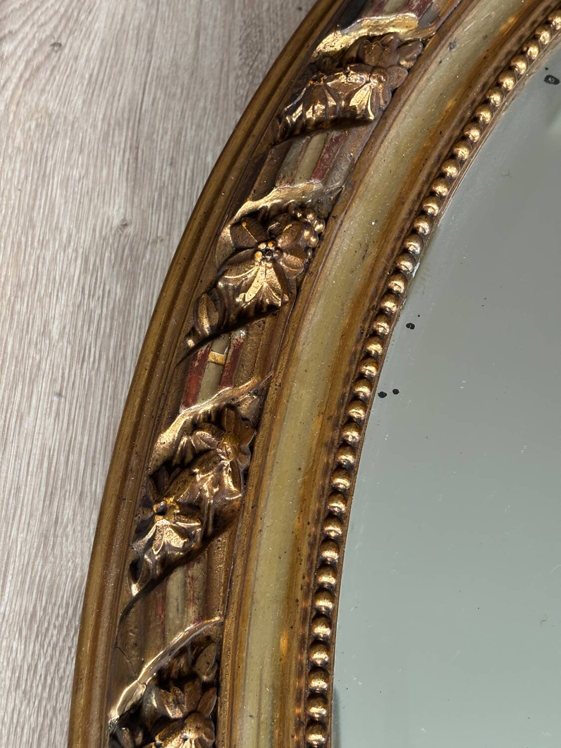 19th century oval gilded mirror, torch & quiver 106cm
