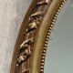 19th century oval gilded mirror, torch & quiver 106cm