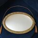 Golden oval mirror with its wooden frame and stucco on wood, nicely cracked by time