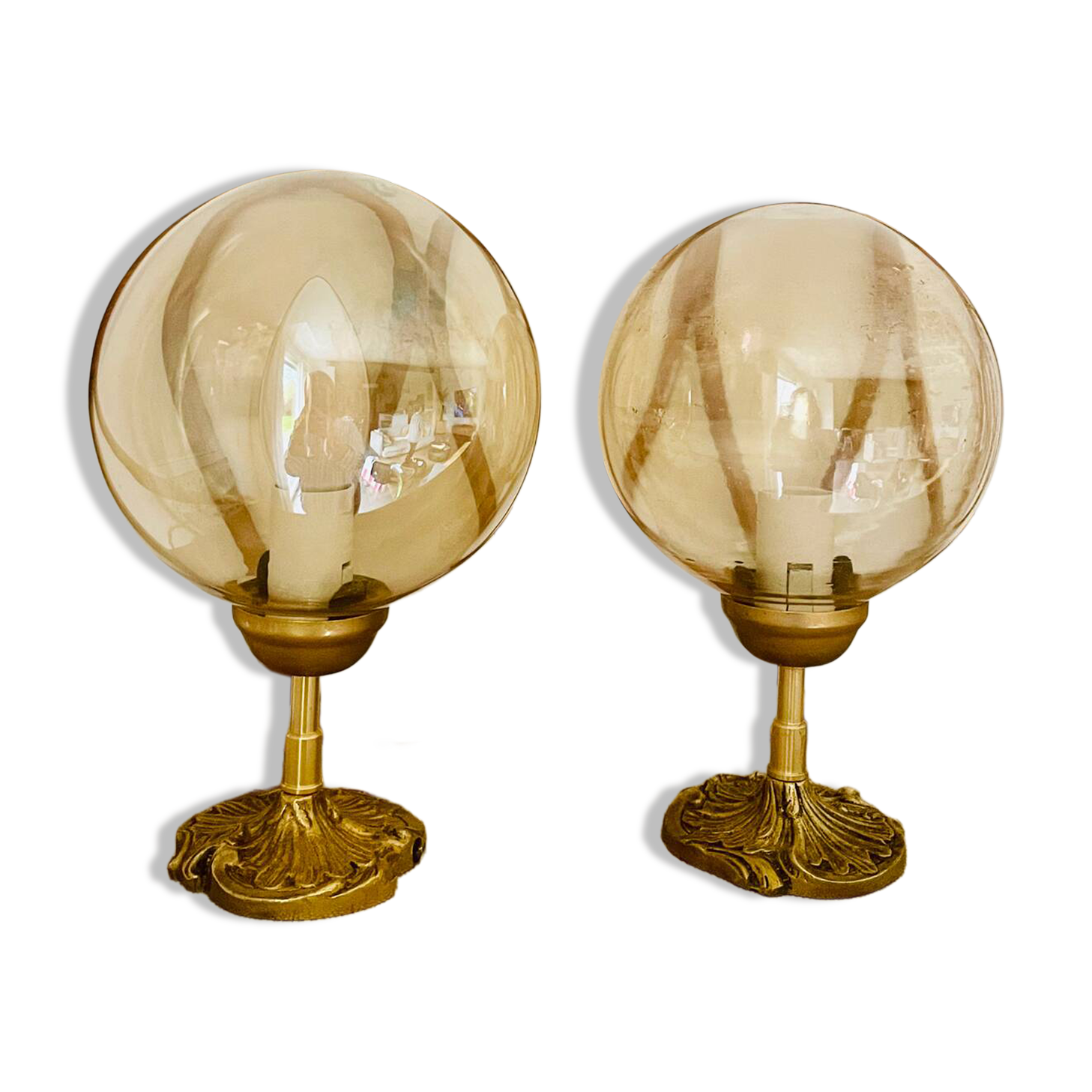 2 bedside lamps with round amber glass globes and gold metal.