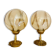 2 bedside lamps with round amber glass globes and gold metal.