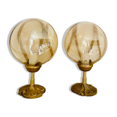 2 bedside lamps with round amber glass globes and gold metal.