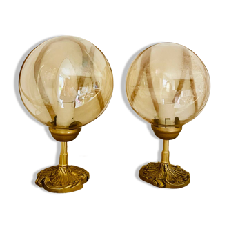 2 bedside lamps with round amber glass globes and gold metal.
