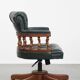 Dark green leather Chesterfield office chair on wheels.