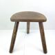 Ancient tripod milking stool - field theme, nature
