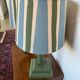 Pair of vintage wooden lamps with their striped beige, blue, and green shades.