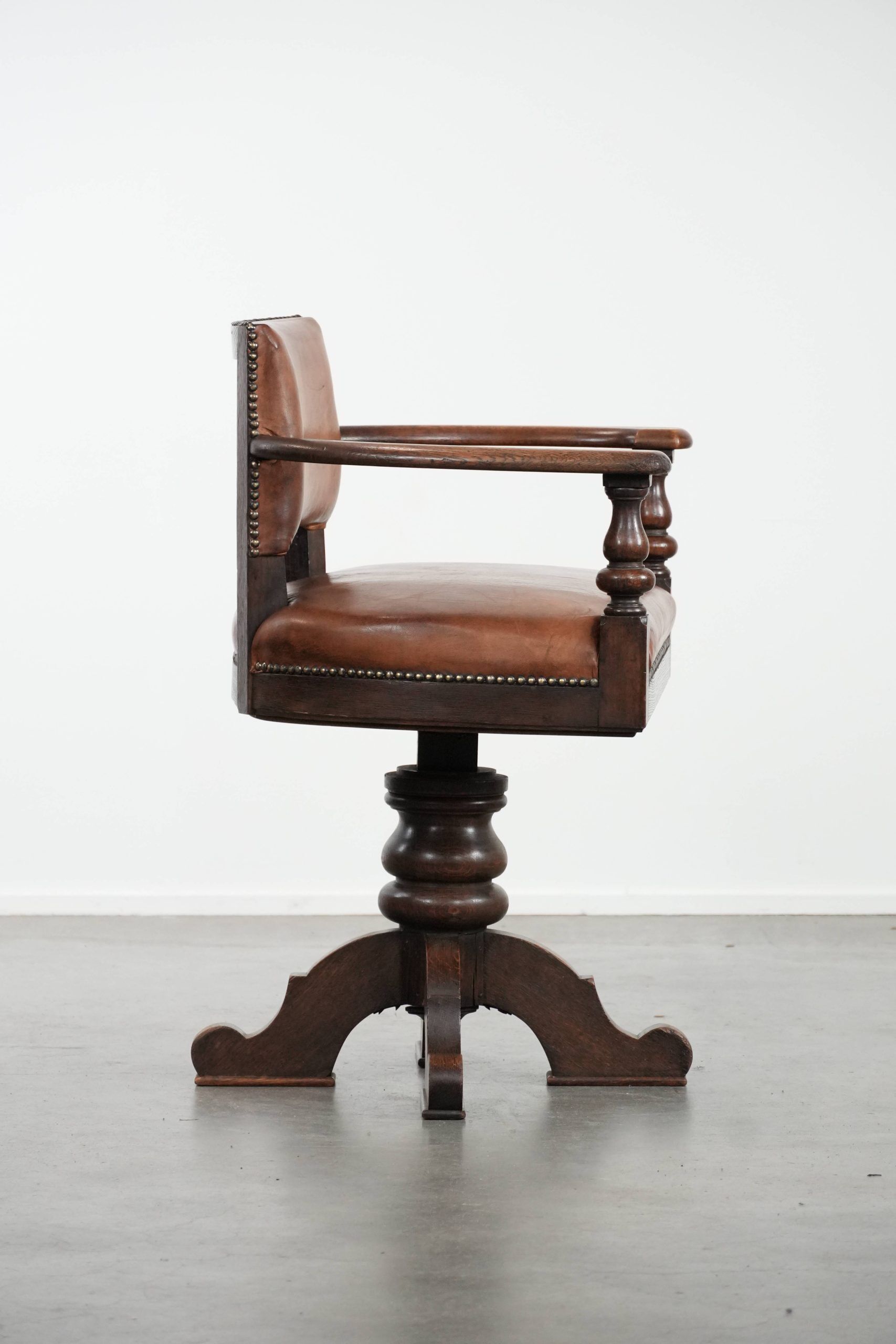 Elegant antique sheepskin leather desk chair with a heavy wooden frame