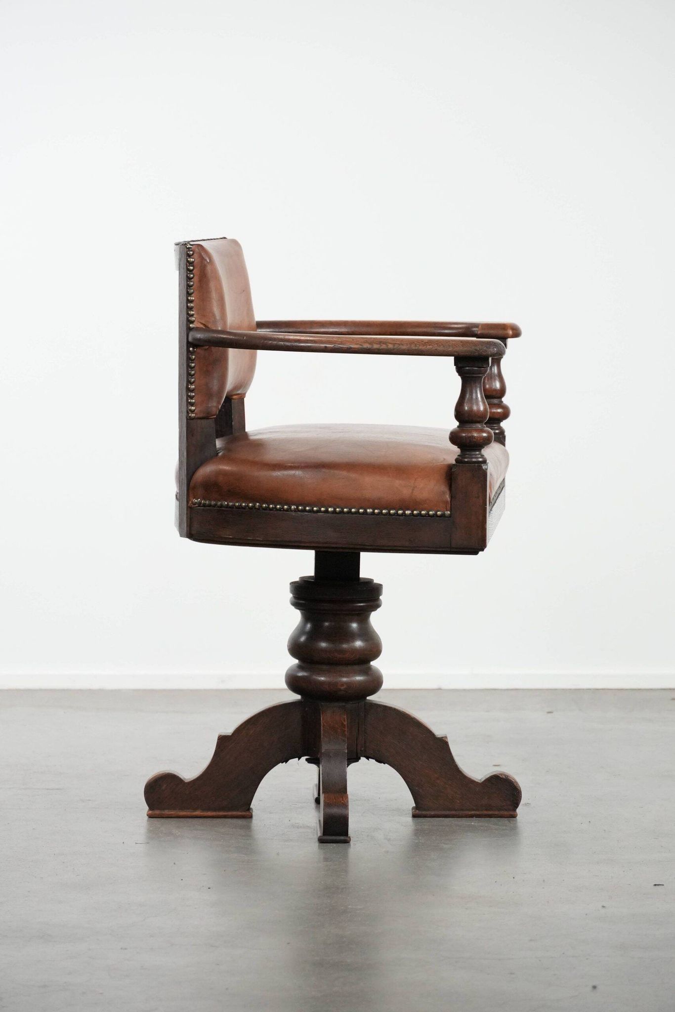 Elegant antique sheepskin leather desk chair with a heavy wooden frame