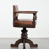 Elegant antique sheepskin leather desk chair with a heavy wooden frame