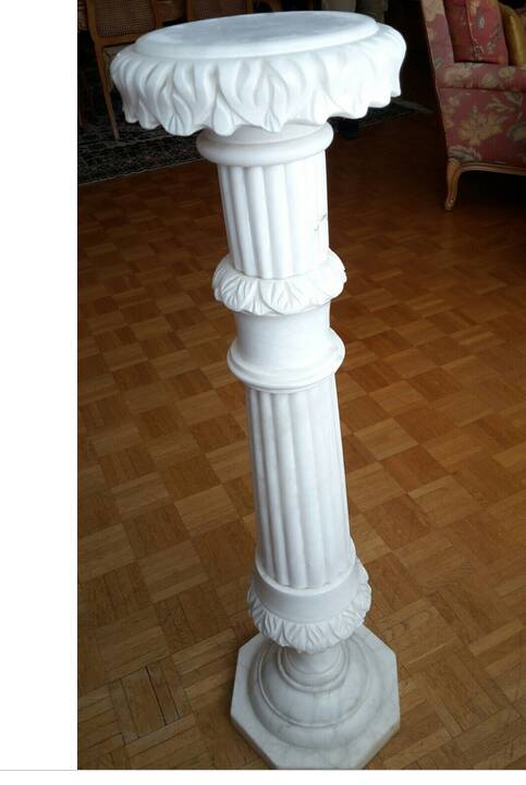 Fluted white marble stand column with floral motifs.