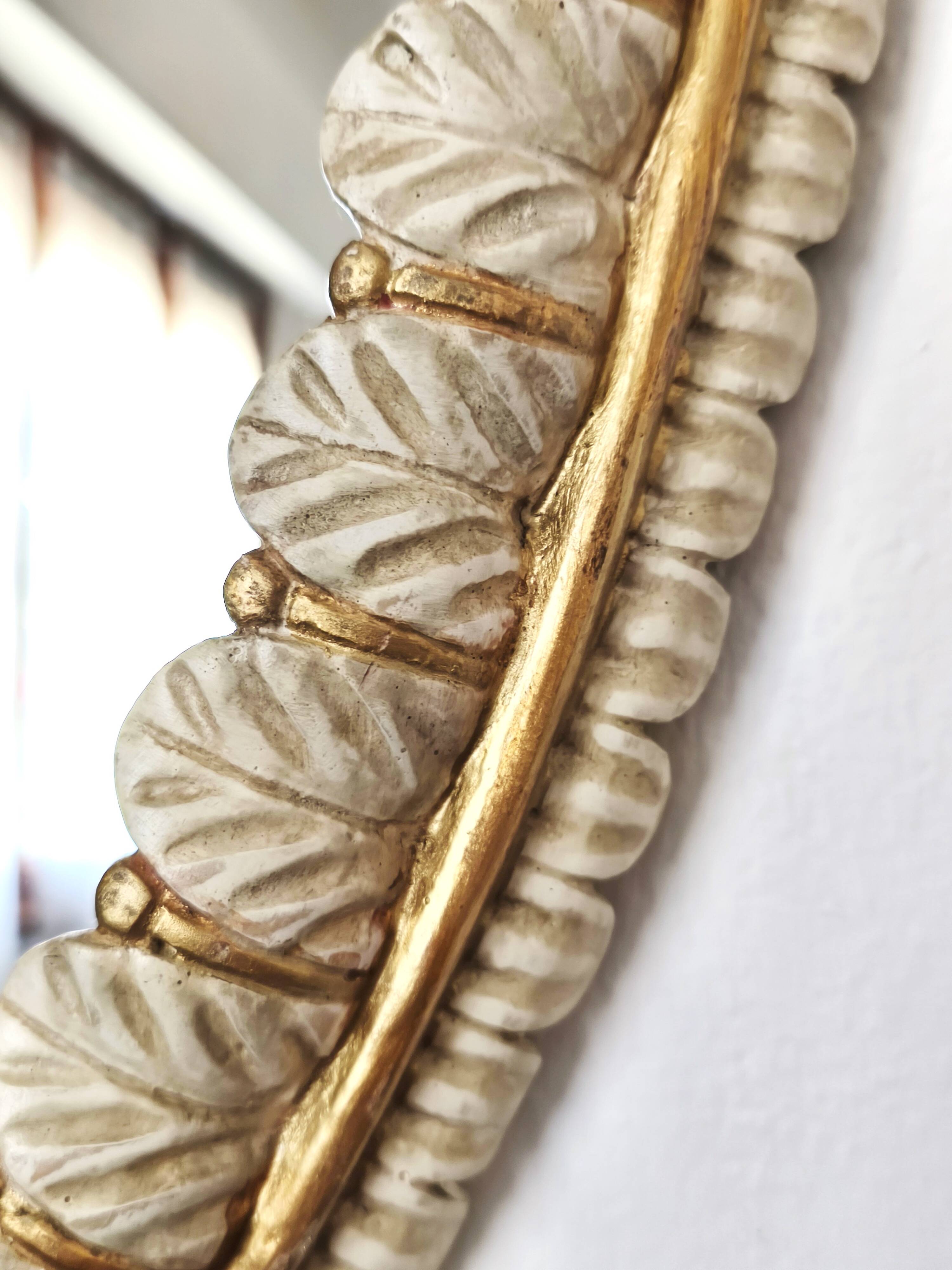 Large oval Florentine mirror in carved wood and gilded with gold leaf.