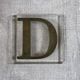 Metal letter D on glass plate