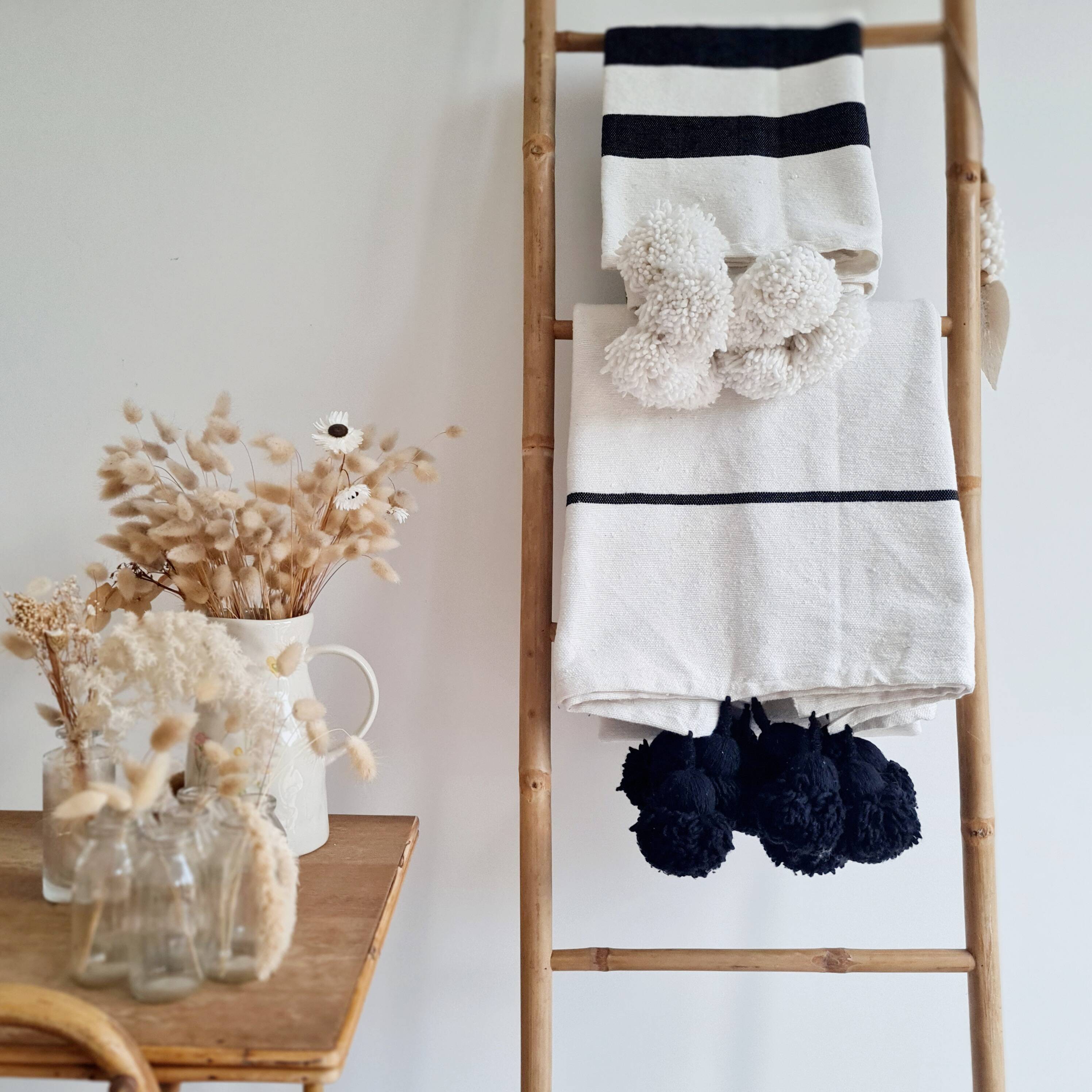 Plaid tissé main rayures noires pompons blancs