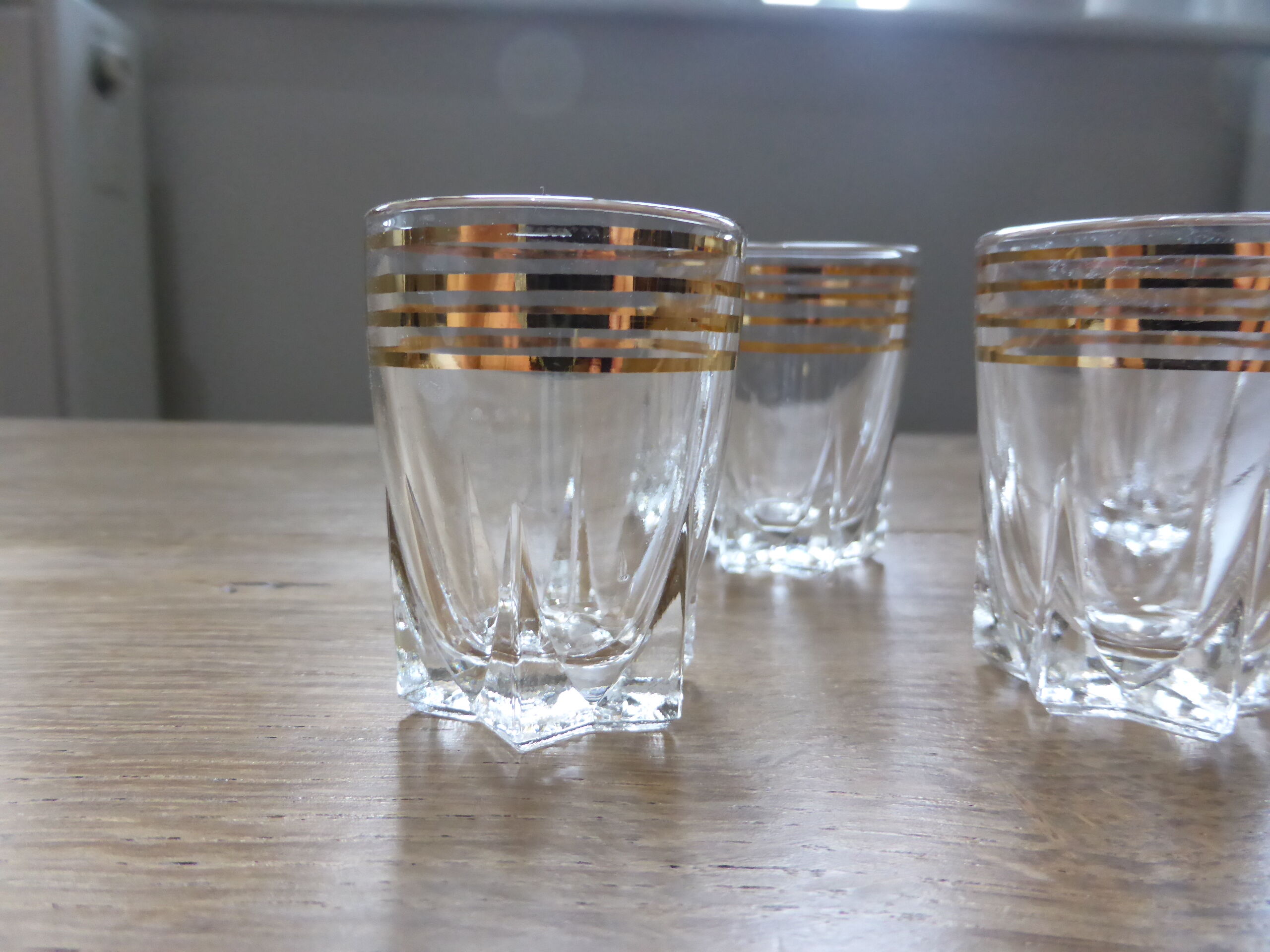 6 clear liquor glasses with golden edict
