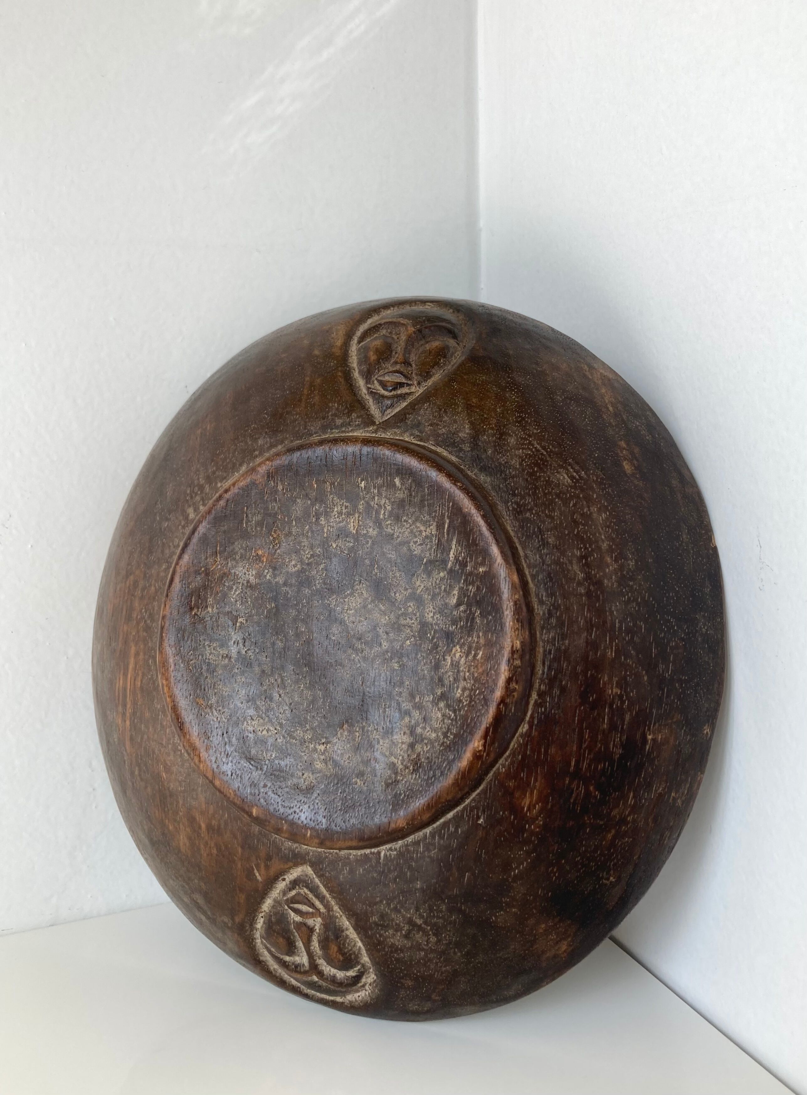 Vintage African tidy in natural wood with carved decoration in flat masks