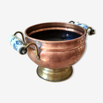 Old brass and copper bucket, cauldron on foot with ceramic handles