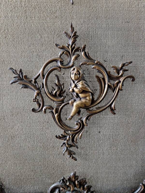 Spark screen, fire screen, bronze fireplace screen decorated with a covered cherub