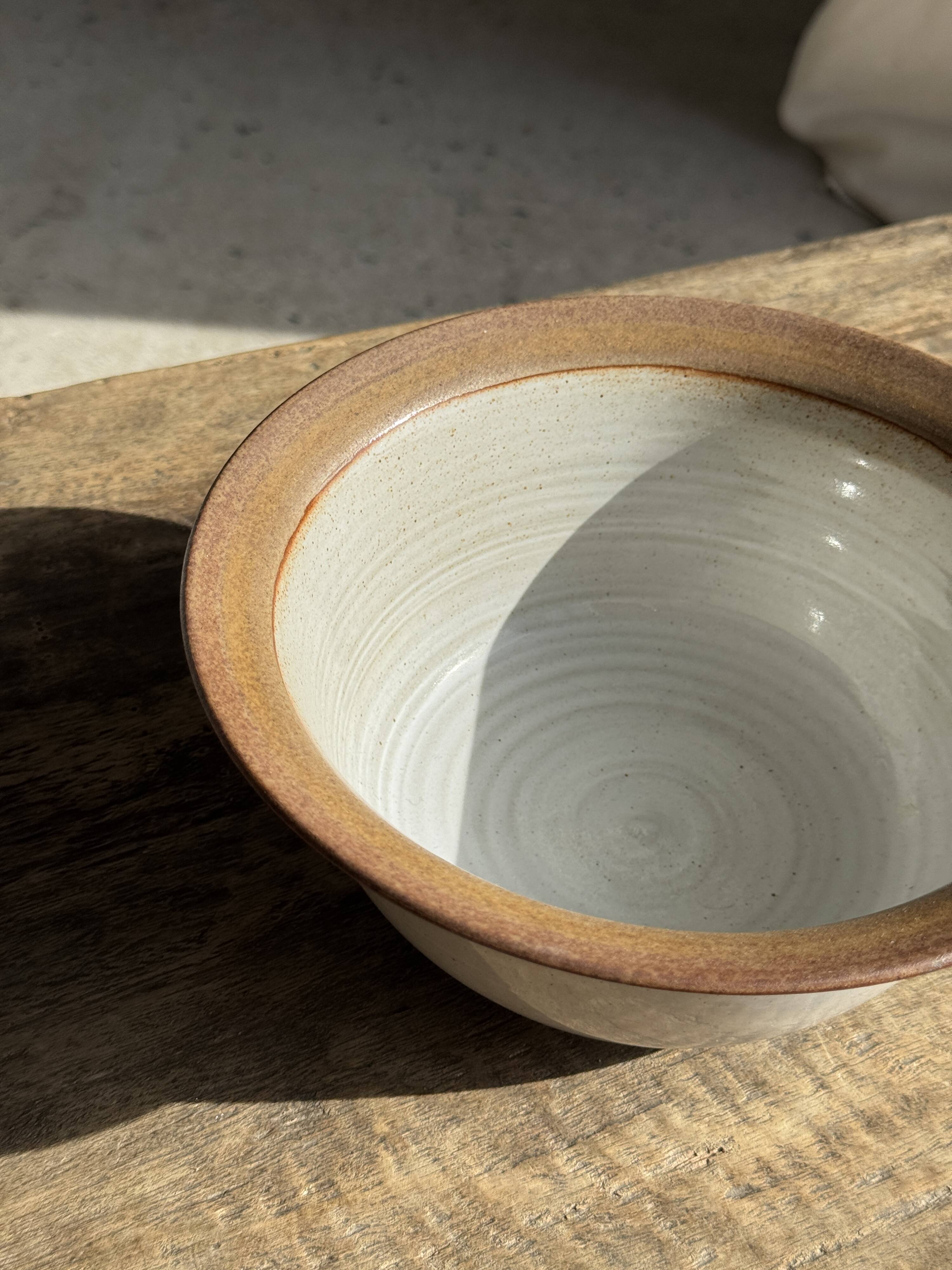 Small thick stoneware bowl with a stylised flower pattern in white on the outside, b