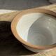 Small thick stoneware bowl with a stylised flower pattern in white on the outside, b