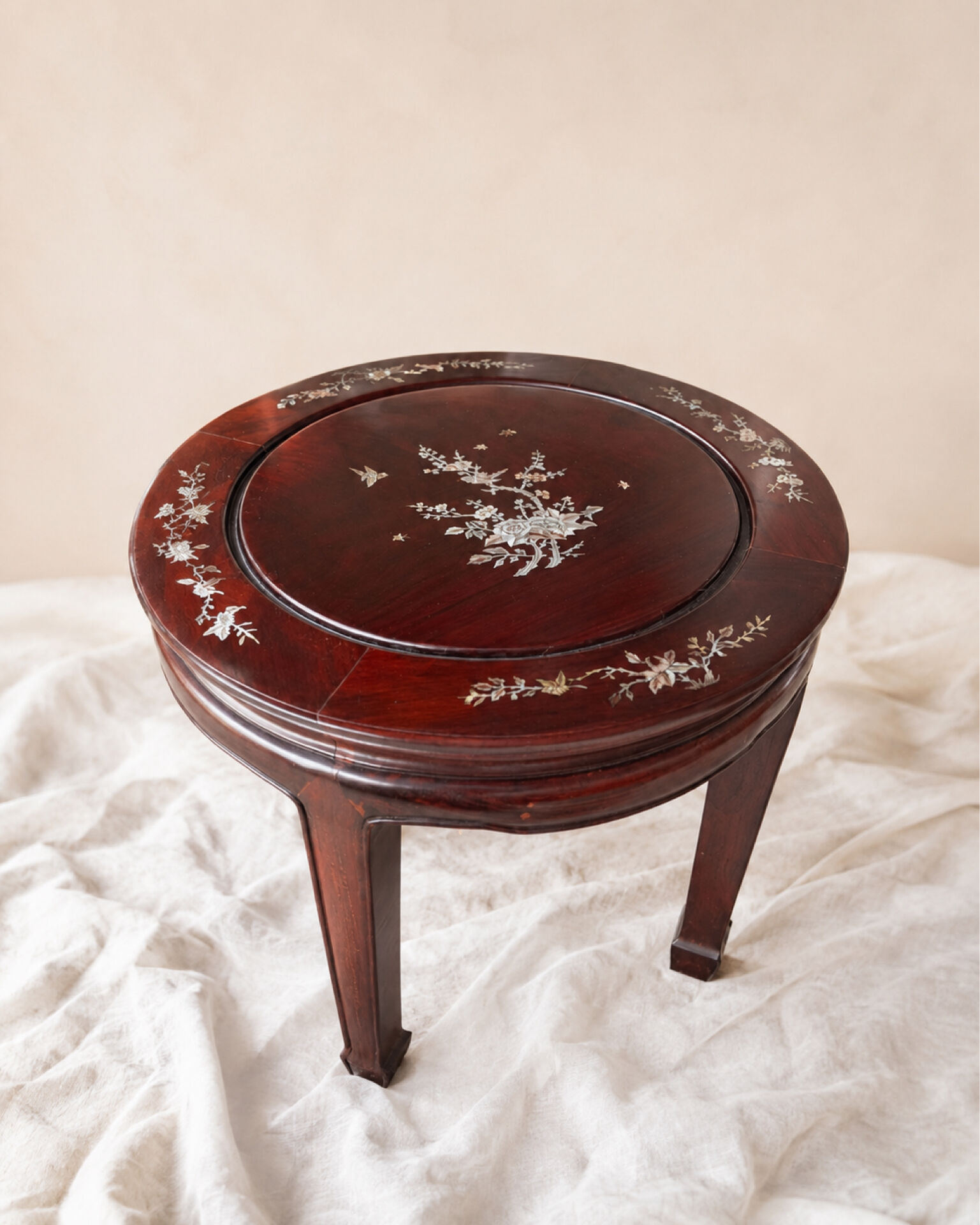 Mahogany gueridon with mother-of-pearl inlays featuring Asian floral decor.