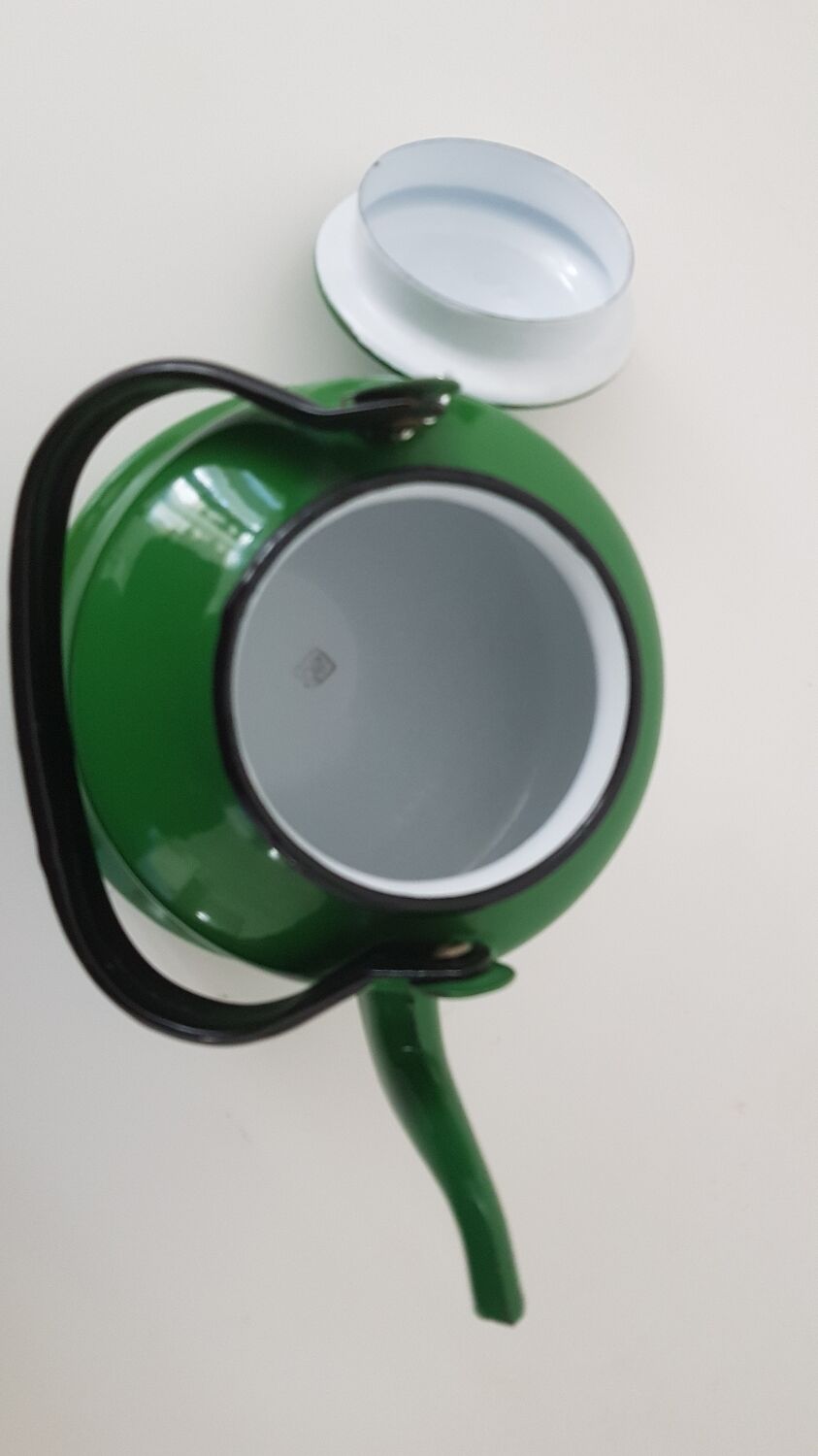 Old green kettle in enamelled metal