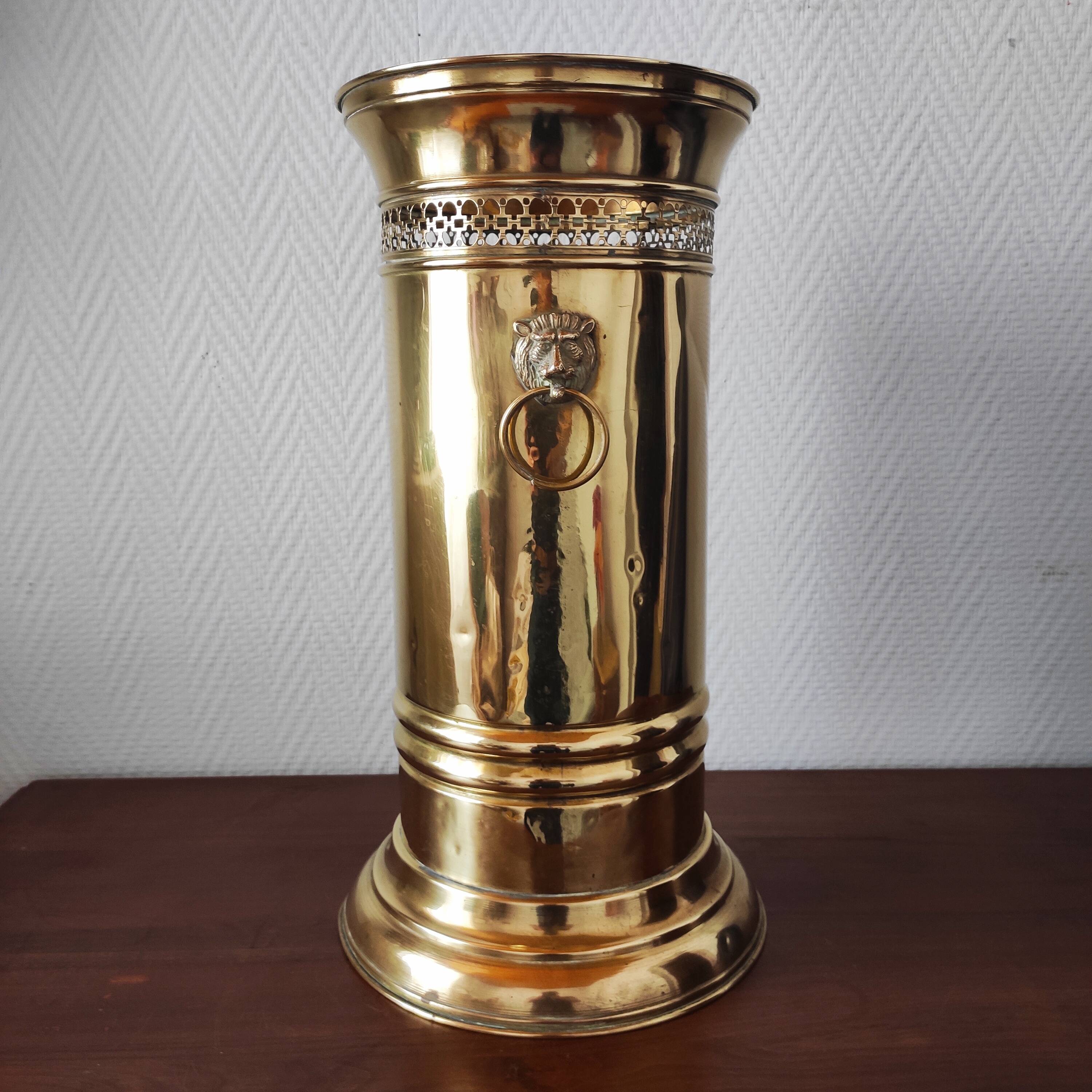 Vintage brass umbrella stand with lion decoration.